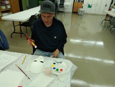 Participant Chris paints his mask for unmasking brain injury